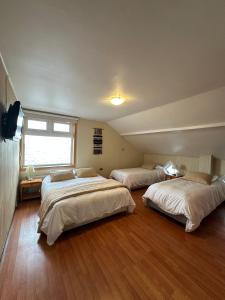 a bedroom with three beds and a window at Hotel Casona Freire in Puerto Varas