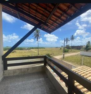 einen Balkon mit Blick auf ein Feld und Palmen in der Unterkunft Casa de Praia Lucena in Lucena