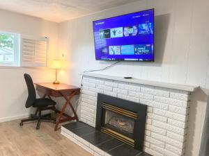 a living room with a fireplace with a television above it at Private Cozy 2bdrm Sleep5pp Metrotown! Free Parking! Self Check-in! in Burnaby