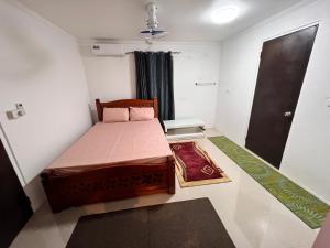 a small bedroom with a bed and a door at Carerras Tranquil Retreat in Nadi International Airport