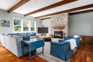 a living room with blue couches and a fireplace at Langley House - Water & Mountain Views, Hot Tub, Firepit in Langley