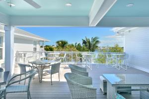Un balcón con mesas y sillas y vistas al océano. en Bayview South 801 Eisenhower Dr. #6, en Key West