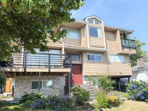 a house with a red door and flowers at Private Cozy 2bdrm Sleep5pp Metrotown! Free Parking! Self Check-in! in Burnaby