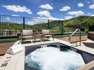 a jacuzzi tub on a patio with mountains in the background at Sheraton Steamboat Resort Villas Hotel Apartment with Resort Access in Steamboat Springs