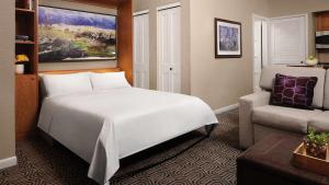 a bedroom with a large white bed and a couch at Marriott's StreamSide - Birch Studio Apartment with Resort Access in Vail