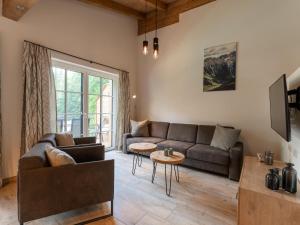 een woonkamer met een bank en een tafel bij Tauernlodge Eben C1 in Eben im Pongau