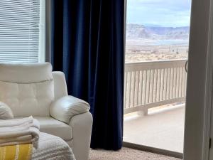 a living room with a chair and a view of the desert at Lake Powell Views and Prime Location in Page +38 photos