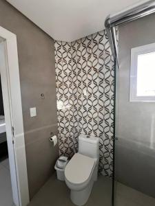 a bathroom with a toilet and a shower at Apartamento na Praia da Vila in Imbituba +6 photos