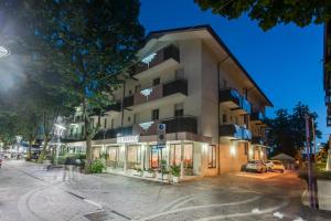 un bâtiment au coin d'une rue la nuit dans l'établissement Hotel Basilea, à Bellaria-Igea Marina