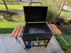 a barbecue grill sitting on a picnic table next to a bench at La muñeca Chalet in Circasia