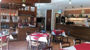 a restaurant with red and white tables and a bar at Agriturismo Monte Del Re in San Pietro al Natisone