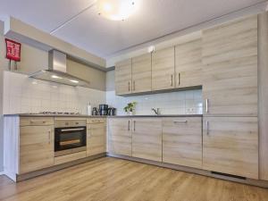 a large kitchen with wooden cabinets and a stove at t Katreel in Rietmolen