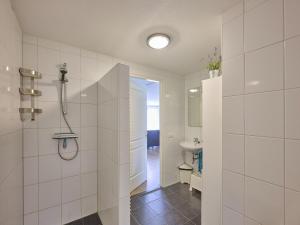 a white bathroom with a shower and a sink at t Katreel in Rietmolen +38 photos