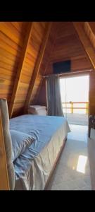 a large bed in a room with a wooden ceiling at Chalé Parada do Vale in Planalto