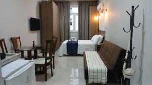 a hotel room with a bed and a table at Flat Centro Rio Av Presidente Vargas x Uruguaiana - Vista panorâmica do Cristo & Metrô in Rio de Janeiro