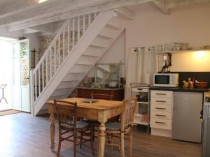 a kitchen with a wooden table and a staircase at Gîte charmant avec terrasse privative et vélos, proche thalassothérapie et balnéothérapie - FR-1-426-332 in Talmont-Saint-Hilaire +11 photos