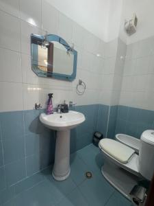 a bathroom with a sink and a toilet and a mirror at Family Apartment 02 in Shkodër