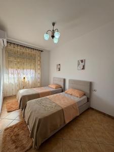 a bedroom with two beds and a window at Family Apartment 02 in Shkodër