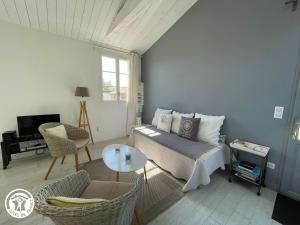 a living room with a couch and a table at Gîte en plein bourg avec terrasse ensoleillée, vélos à disposition et parking – proche thalasso et plages - FR-1-426-290 in Talmont-Saint-Hilaire