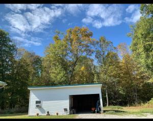 un grande garage bianco con una porta aperta di Country Getaway a Stewart
