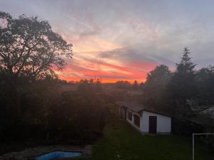 een zonsondergang boven een huis in een veld bij Vorstadt-Villa Apfelroute in Alfter