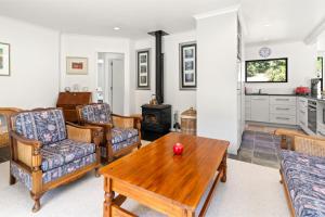 a living room with a table and chairs and a stove at Hill Cottage - Featherston Holiday Home in Featherston