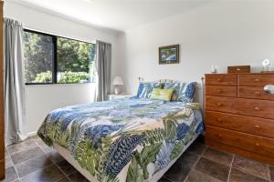 a bedroom with a bed and a dresser and a window at Hill Cottage - Featherston Holiday Home in Featherston