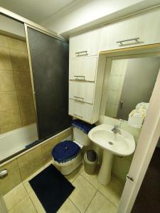a bathroom with a sink and a toilet and a mirror at Departamento acogedor Arica in Arica +13 photos