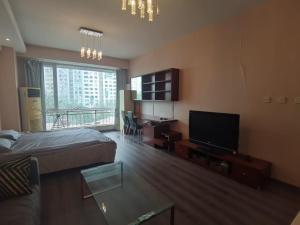 a living room with a bed and a television at Apple Community North District Serviced Apartment in Beijing