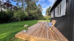 une terrasse en bois avec une table et une chaise. dans l'établissement 8171-Praesto-Solsortvej-11, à Præstø