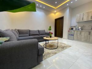 a living room with a couch and a table at عين دبي للشقق المفروشة-عائلات in Taif