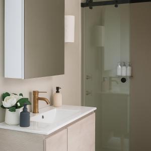 a bathroom with a sink and a mirror and a shower at Fun Family Escape with Highland Cows in Medowie