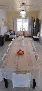 Una gran mesa de comedor con sillas blancas y una mesa de comedor. en Laguna de Gómez Ensueño, en Junín