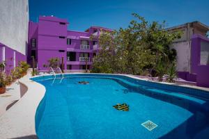 a swimming pool in front of a building at Hotel Vista del Mar with Beach Club access included in Cozumel