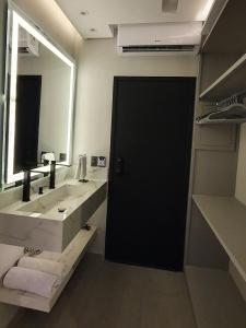 a bathroom with a sink and a large mirror at Pousada Exclusive in Florianópolis