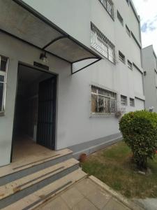 um edifício branco com uma porta e uma varanda em Ipiranga Flat - Guarapari, Espírito Santo em Guarapari