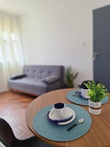 uma mesa de madeira com dois pratos e uma xícara de café em Ipiranga Flat - Guarapari, Espírito Santo em Guarapari