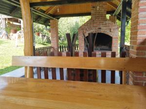 eine Holzbank vor einem gemauerten Kamin in der Unterkunft Holiday Home Katica - Two-Bedroom Holiday Home in Donja Stubica + 17 Fotos