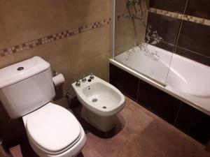 a bathroom with a toilet and a sink and a tub at departamento en parque Necochea in Necochea