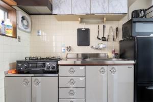 cocina con fregadero y nevera negra en Atlantis 天下茶屋, en Osaka