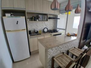 a kitchen with a white refrigerator and a counter at Apartamento Familia Granja Viana in Carapicuíba