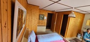 Una habitación con una cama y una mujer parada en ella. en Alphenrose saxeten, en Saxeten