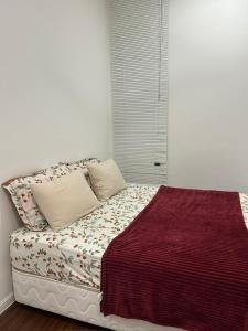 Una cama con dos almohadas y una manta encima. en Ella Residence Homestay, en Brinchang