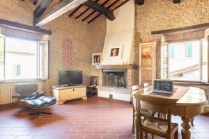 a living room with a laptop on a table and a fireplace at Casa Vacanze in pietra del '700 in San Leo