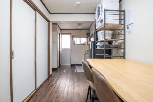 comedor con mesa, sillas y escalera en Atlantis 天下茶屋, en Osaka