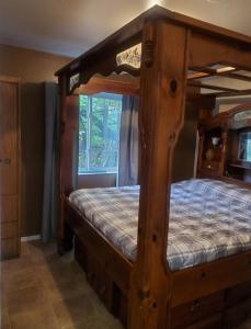 a wooden bunk bed in a room with a window at Hot Tub with King Bed in Anchorage