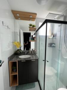 a bathroom with a sink and a shower at Apartamento próximo a Orla de Atalaia in Aracaju