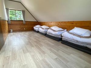 a room with four beds in it with a wooden floor at 絶景cottageまるっと貸切り 星空D棟 in Nasushiobara
