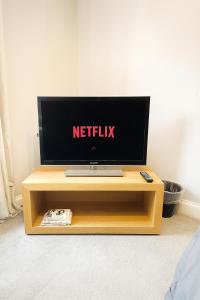 a television sitting on a wooden table in a room at Modern 2-Bedroom London Base - 15 mins to Central London - Next to East Croydon Station - Sleeps 5 in Croydon