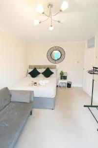a bedroom with a bed and a couch at Modern 2-Bedroom London Base - 15 mins to Central London - Next to East Croydon Station - Sleeps 5 in Croydon